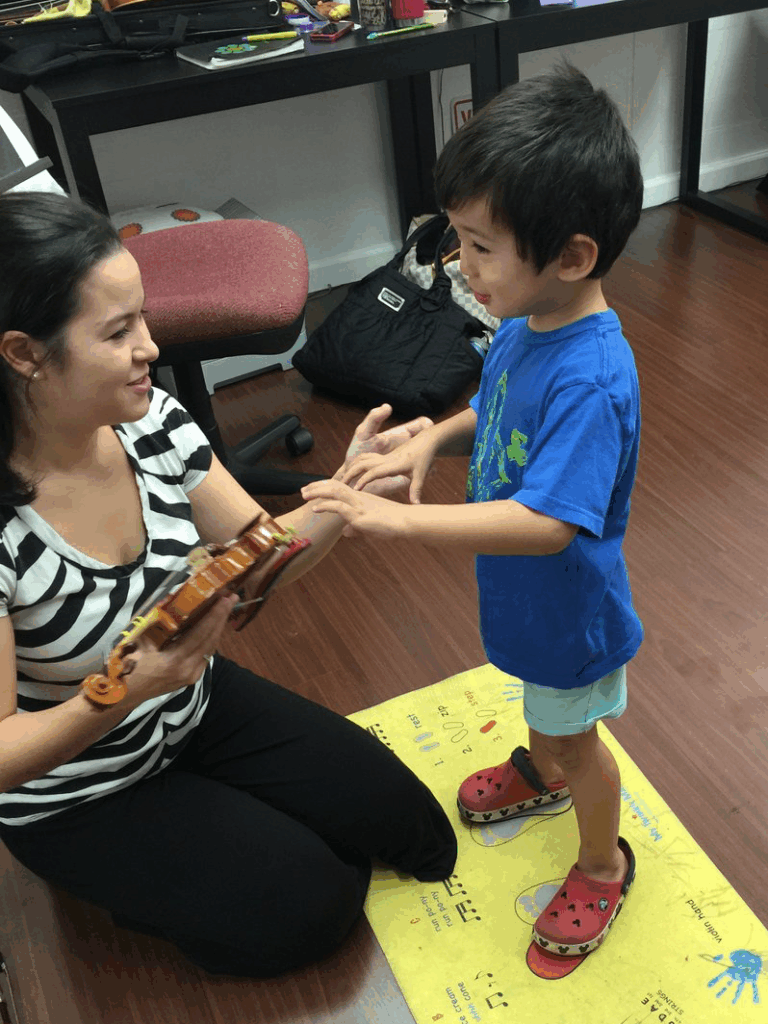 Dr. Nikki Ebisu teaching child violin